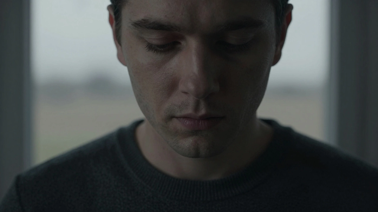 Человек в темно-сером свитере с тенями под глазами и тусклой кожей под холодным светом.